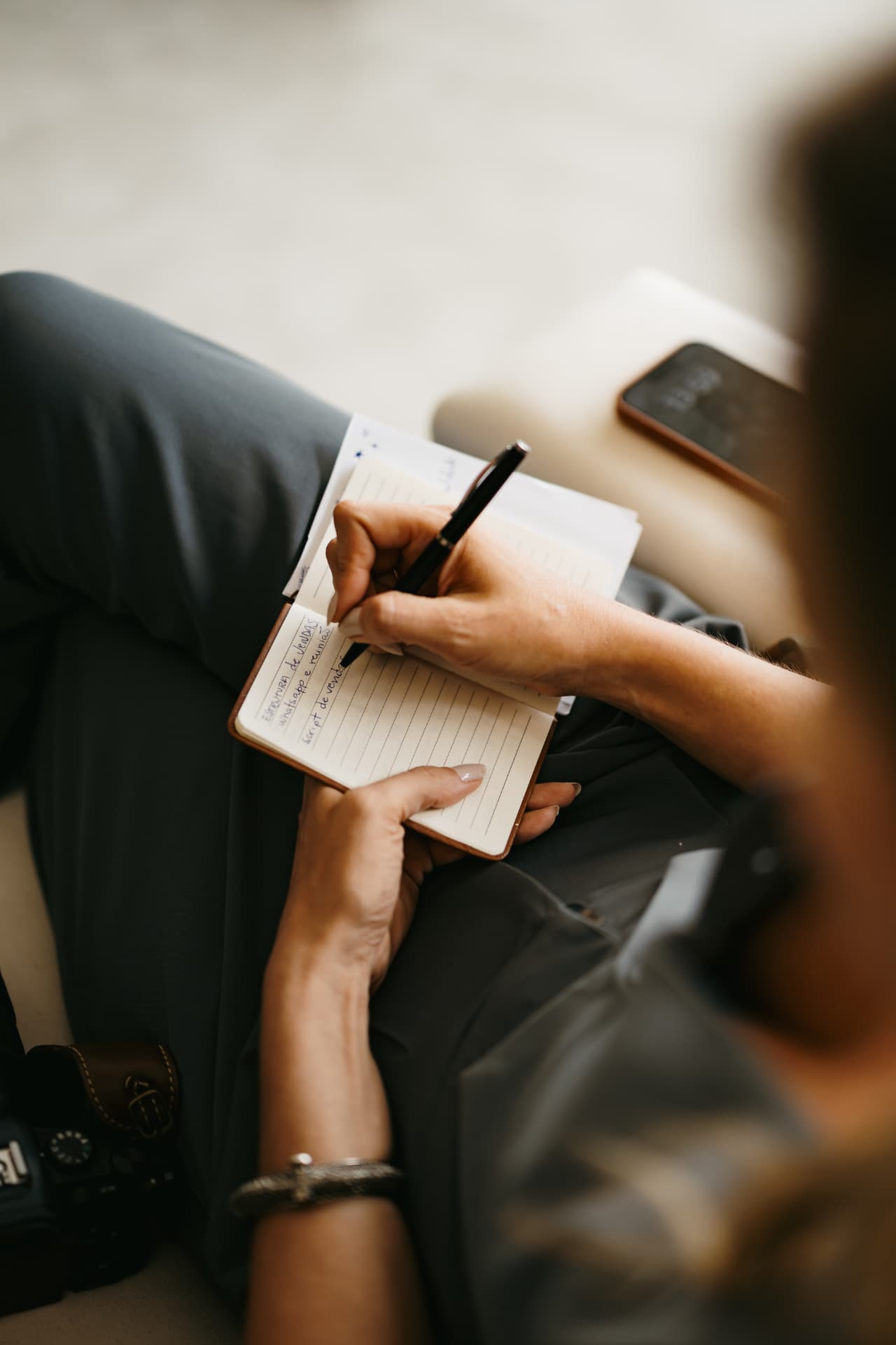 Mãos fazendo anotações num caderno durante a mentoria