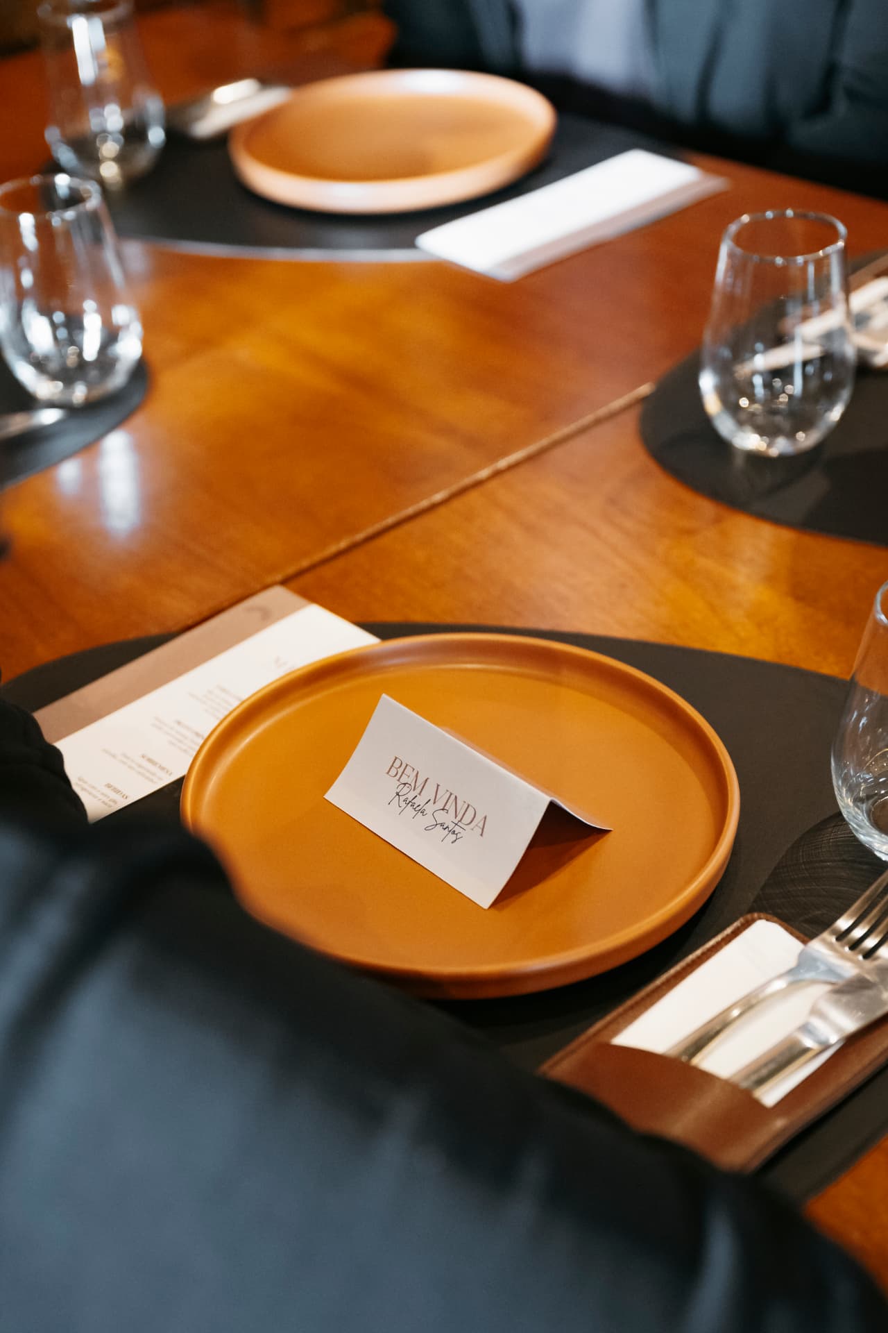 Mesa posta para o almoço da mentoria, com cartão de boas-vindas no prato